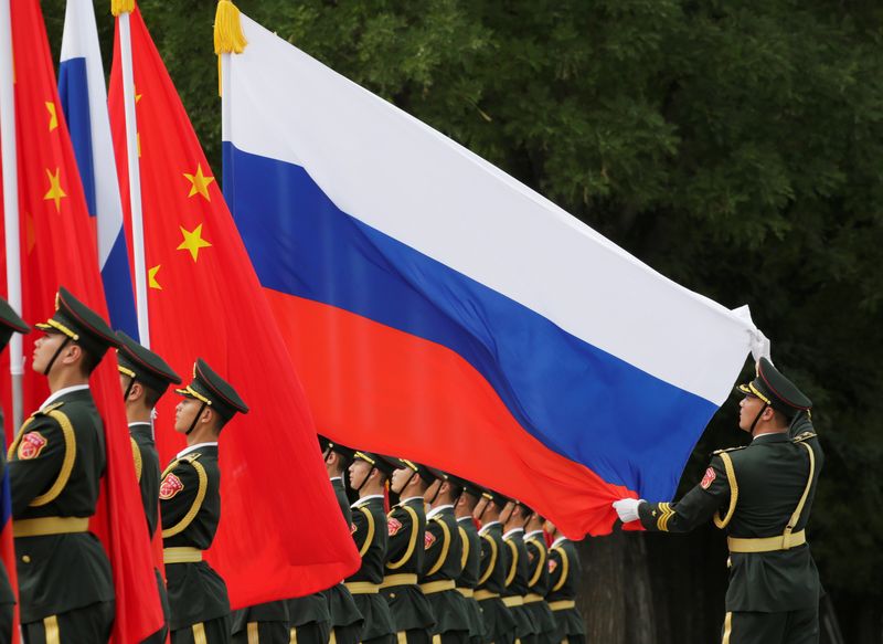 FILE PHOTO: A military officer adjusts a Russian flag ahead of a welcome ceremony in Beijing